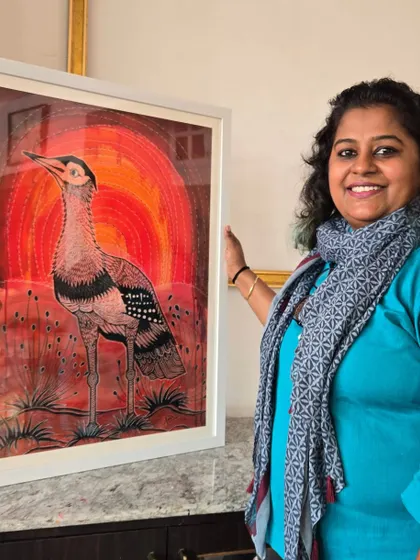 Artist Puja Kumari is pictured with her artwork of an endangered bird, created with her signature style of ink and dried leaves. Her exhibition "Vibing with Nature" raises awareness for wildlife conservation.