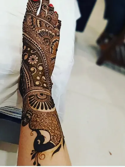 A beautiful peacock design that flows from the ankle down to the foot. This style of foot mehendi is very graceful and looks wonderful in photos.