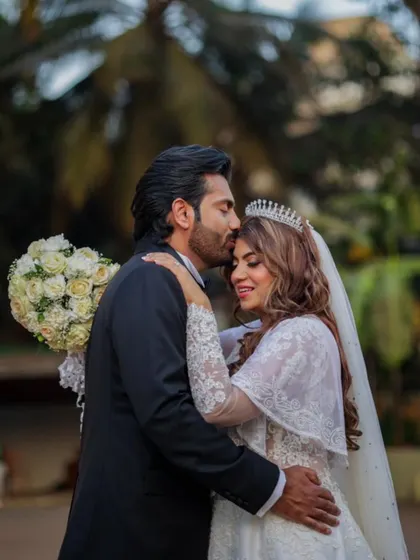 A tender moment between the bride and groom. Her beautiful, long waves and sparkling tiara create a look of pure romance.