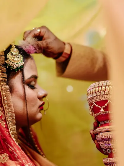 The Sindoor Daan is one of the most profound moments in an Indian wedding. I framed this shot to focus on the bride's reverent expression and the gentle application of the sindoor, capturing the solemnity and emotion of this sacred ritual.