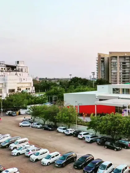 A view of the Glass Pavilion and its surroundings, including the organized parking area and adjacent buildings.