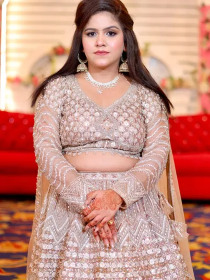 A full portrait showing her beautiful, intricately embroidered lehenga. The makeup is classic and timeless.
