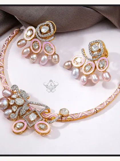 A unique and feminine necklace set featuring pink enamel, baroque pearls, and polki diamonds. The crescent-shaped necklace is a true statement of artistry and style.