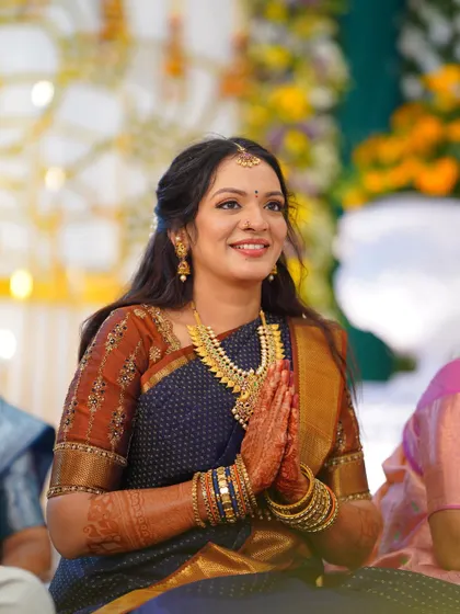 A candid shot of the bride during her engagement ceremony. Her makeup is fresh and luminous, capturing her happiness and excitement.