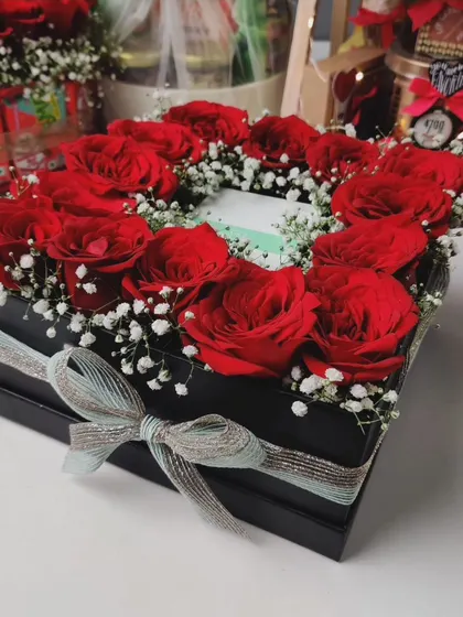 A heart-shaped arrangement of red roses in a sleek black gift box. This is an elegant and timeless gift for someone special.