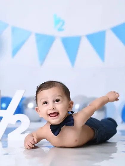 Half a year of pure joy! This little boy is celebrating his 6-month milestone with a fun, superhero-like pose.