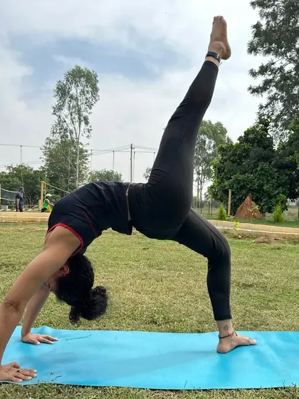 A duplicate of ID 70, showing a teacher in a powerful backbend during an outdoor yoga retreat. The natural surroundings amplify the sense of connection and freedom in the practice.