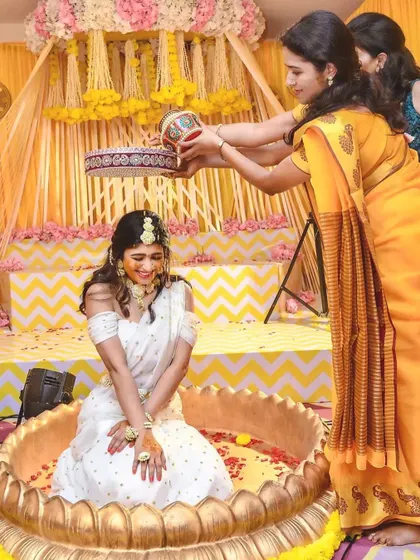 Capturing the pure joy of the Haldi ceremony. The bride is showered with flowers and turmeric, and my decor with its bright yellow drapes and floral accents creates a perfectly festive atmosphere.