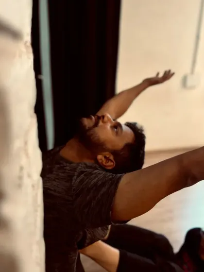 A dancer uses the wall for support in a deep backbend, a great way to safely explore and expand flexibility.