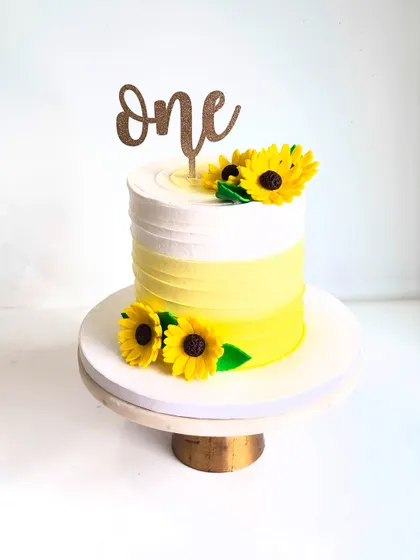 A bright and cheerful pineapple cake for a first birthday cake smash. The edible, handmade sunflowers add a beautiful touch of sunshine.