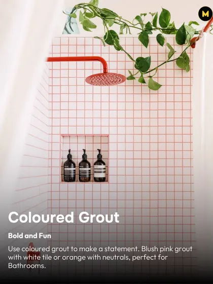Coloured grout is a fun way to make a statement. Here, blush pink grout paired with simple white tiles and a red shower head creates a bold and playful bathroom design.