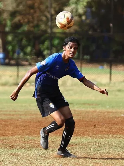 A player controls the ball with his chest, demonstrating composure and technique during a competitive match.