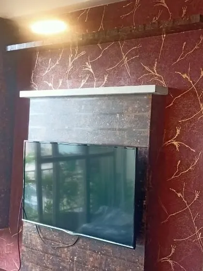 I updated this living room by wrapping the TV entertainment unit and the wall behind it. The rich maroon and gold patterned wall covering adds a touch of luxury, while the dark textured wrap on the unit itself gives it a sleek, contemporary finish. It’s an effective way to make your media center a focal point.