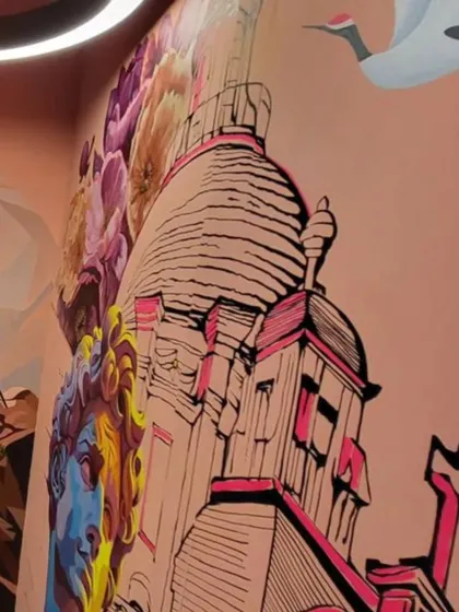 A different angle of the 'Raahi' mural, showing how the classical bust, flowers, and architectural drawings blend together in a dynamic composition.