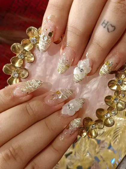 An intricate design combining gold threadwork, 3D floral accents, and gold flakes for a truly unique look.