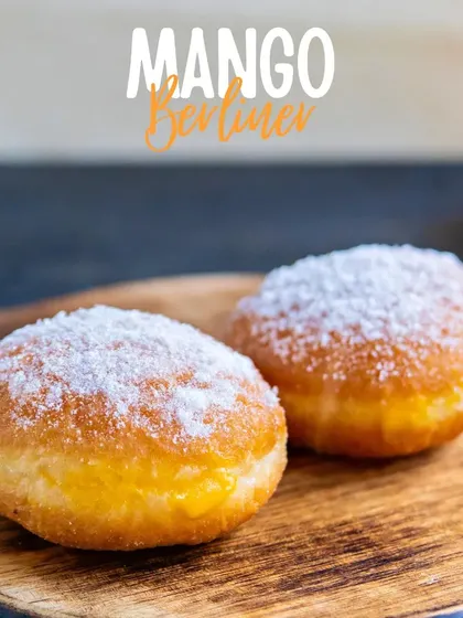 Our take on a classic German doughnut, the Mango Berliner. These soft, fluffy doughnuts are filled with a sweet mango cream and dusted with powdered sugar.