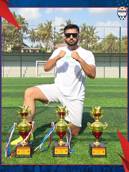 Our coach, kneeling with trophies at the Goa Football Festival. We provide opportunities for our coaches and players to travel and compete.