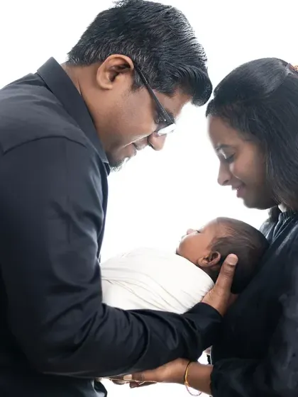A precious moment as new parents gaze at their newborn baby. We use high-key lighting to create a bright, airy, and timeless feel for these first family portraits.