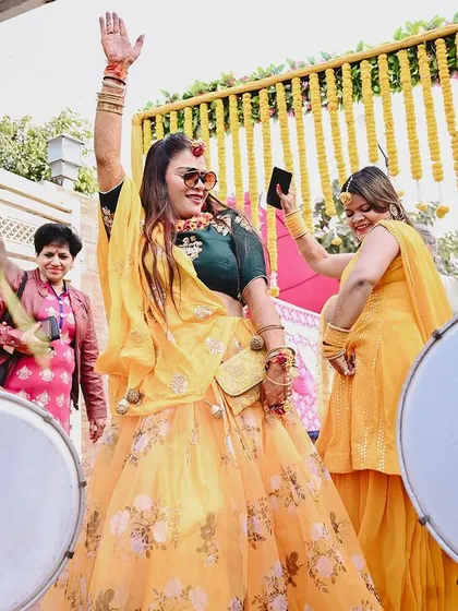 The bride dances with abandon to the beat of the dhol. I focus on capturing the high-energy moments and the vibrant colors of the Haldi ceremony.