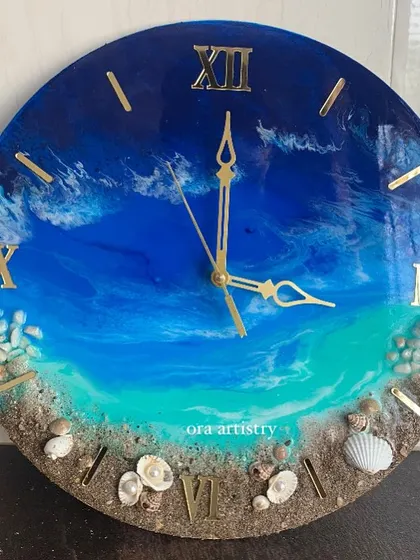 A beautiful ocean clock with deep blue water and a shoreline made with real sand and shells.