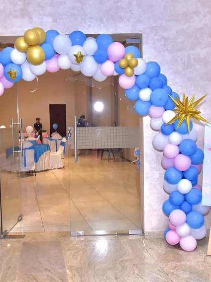 The entrance to a 'Twinkle Twinkle Little Star' party. A balloon arch in pink, blue, and gold, accented with star-shaped foil balloons, creates a magical welcome for the little one and the guests.