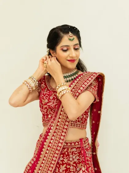 Another angle of the bride getting ready, showing the detail of her eye makeup and how it complements her jewelry.