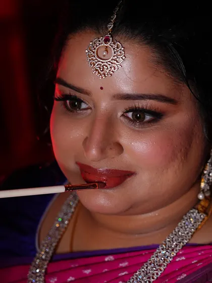 The final touch of lipstick. This close-up shows the beautiful glossy finish that completes her engagement makeup look.