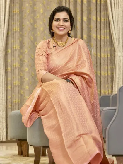 A beautiful peach-colored silk saree. This is a very elegant and sophisticated look, perfect for a formal event or a wedding.