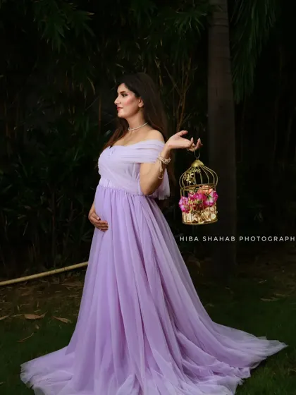 A client looking ethereal in a lavender A-line gown. The off-the-shoulder design and soft, flowing tulle create a romantic and dreamy look, perfect for a garden photoshoot.