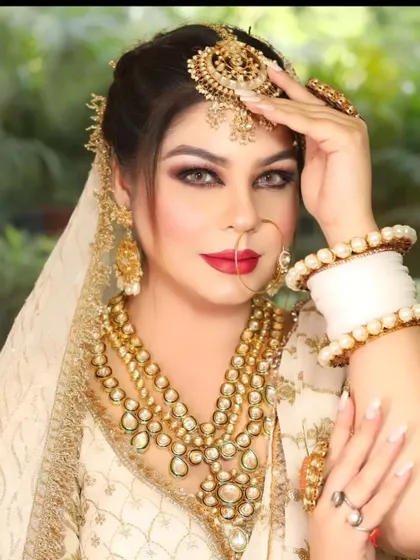 A bride in an ivory lehenga with a stunning layered gold and Kundan rani haar. The look is completed with a matching maang tikka and nath.