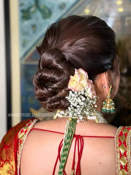 Another view of the traditional bridal bun, showing the placement of carnations and baby's breath. This classic combination is always a favorite among brides.