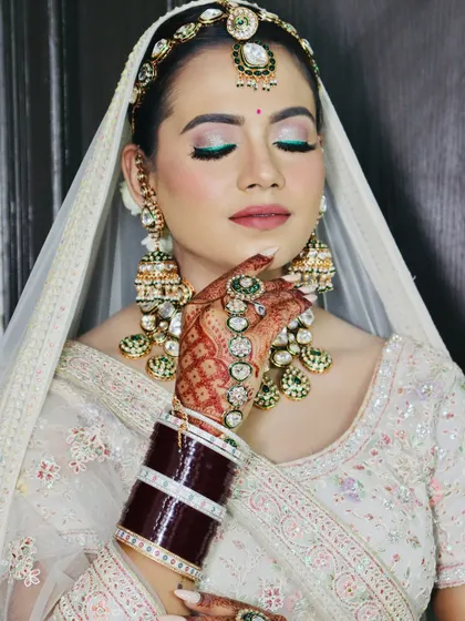 This pose highlights the hand jewelry and henna, along with the detailed makeup.