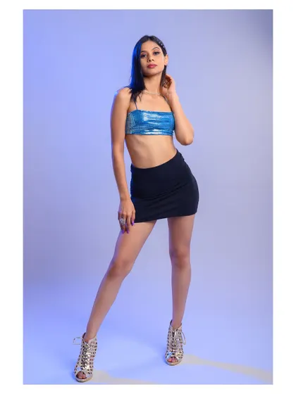 A full-length shot of a model in a party-ready outfit. The cool-toned lighting and confident pose make this a great image for a fashion or nightlife-themed shoot.