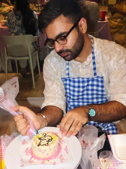 A participant at our birthday workshop decorating his own mini cake with a cute character design. We love seeing everyone's creativity come to life.