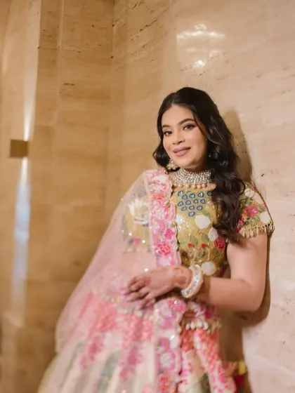 A full shot of the bride in her beautiful floral mehendi outfit, looking relaxed and radiant.