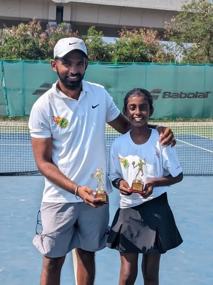 Trisha Bhosale with her coach, holding trophies for Singles Runner-up and Doubles Winner at the U-12 All India Ranking Championship Series in Kalina.