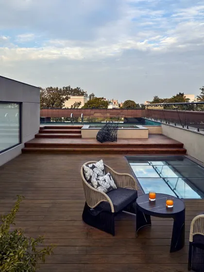 The terrace at the Baid Residence offers breathtaking, uninterrupted views of the Jahanpanah forest. The design of the outdoor space, with its clean lines and natural materials, is intended to connect the home directly with its serene surroundings.