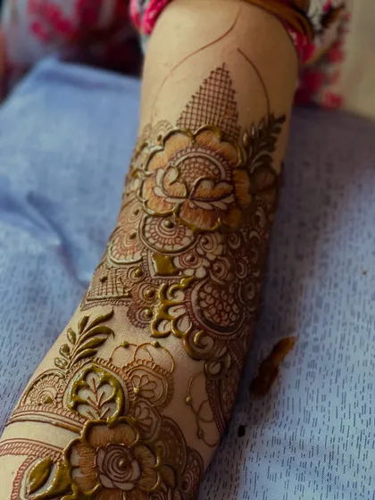 A close-up of the henna paste during application. You can see the raised texture and precision of the linework before the stain develops.