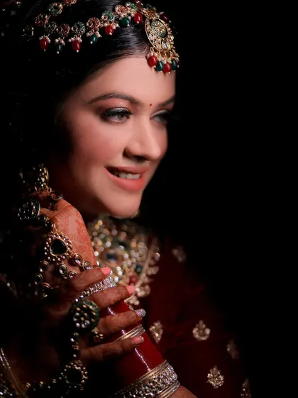A close-up portrait of Kashika, highlighting her flawless makeup and the intricate details of her bridal jewelry.