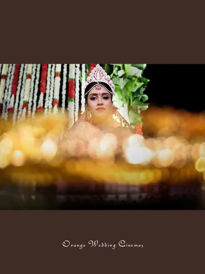 A beautiful bokeh shot of the bride, her face framed by the warm lights of the ceremony.