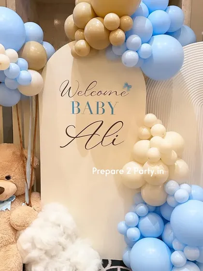 A close-up of the personalized "Welcome Baby Ali" sign. The elegant script and soft color palette of the surrounding balloons create a sophisticated and welcoming focal point.