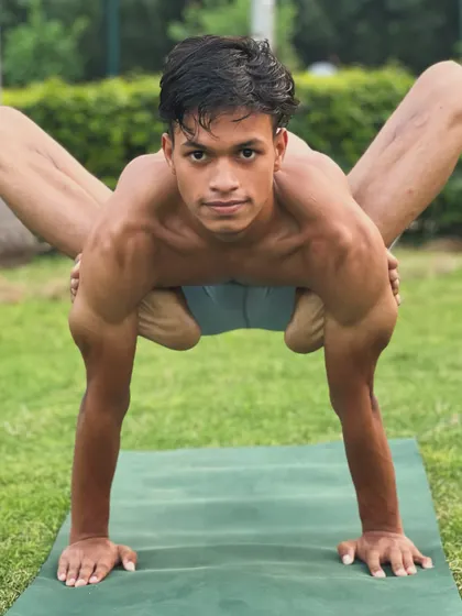 A powerful arm balance that requires open hips and strong shoulders. The direct gaze shows the intense focus required.