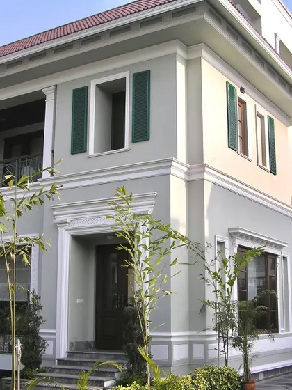 Another angle of the London-inspired villa, showcasing the clean lines and symmetrical balance that define its architectural character. The simple landscaping complements the formal structure.
