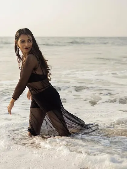 A playful moment in the water, showing how the sheer fabric interacts with the sea.