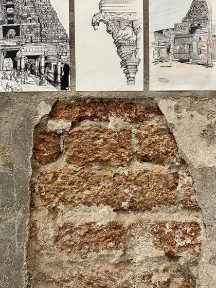 Student drawings displayed against the texture of an old laterite brick wall.