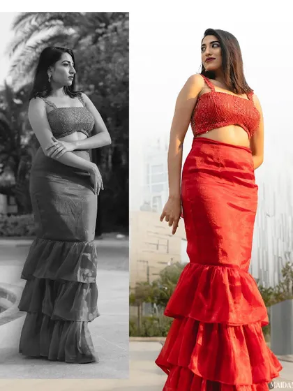 A modern red ensemble designed for a photoshoot. This outfit features a tiered mermaid-style skirt and a matching embellished crop top, creating a bold and fashionable statement.