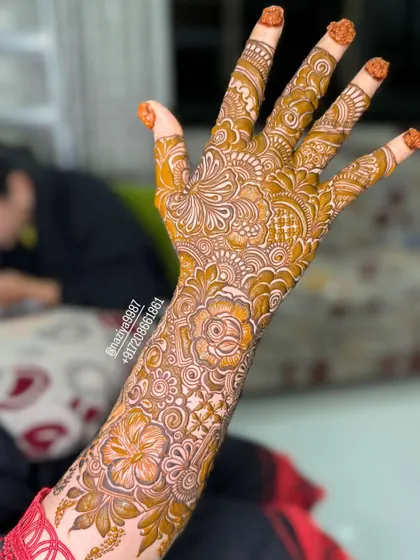 A side view of the intricate bridal design, showing how the pattern wraps around the arm and hand.
