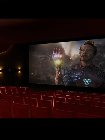 Another shot of the red theater during a movie. The dark walls and ceiling ensure that the screen is the only thing that captures your attention.