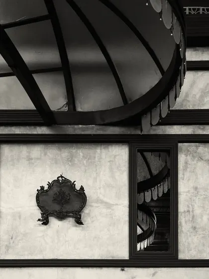 An artistic detail shot showing the reflection of the bar's canopy lights in a window, juxtaposed with a decorative wall plaque. This highlights the layers of detail in the design.