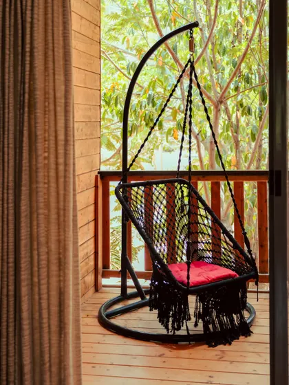 A comfortable hanging swing on a private balcony, offering a unique way to relax and enjoy the view.